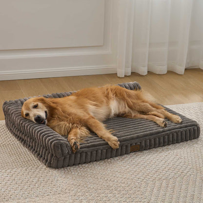 Front view of a dog resting on the Cozy Kiss Striped Faux L-Shaped Washable Dog Bed, showing the raised bolster design. #color_Dark Grey