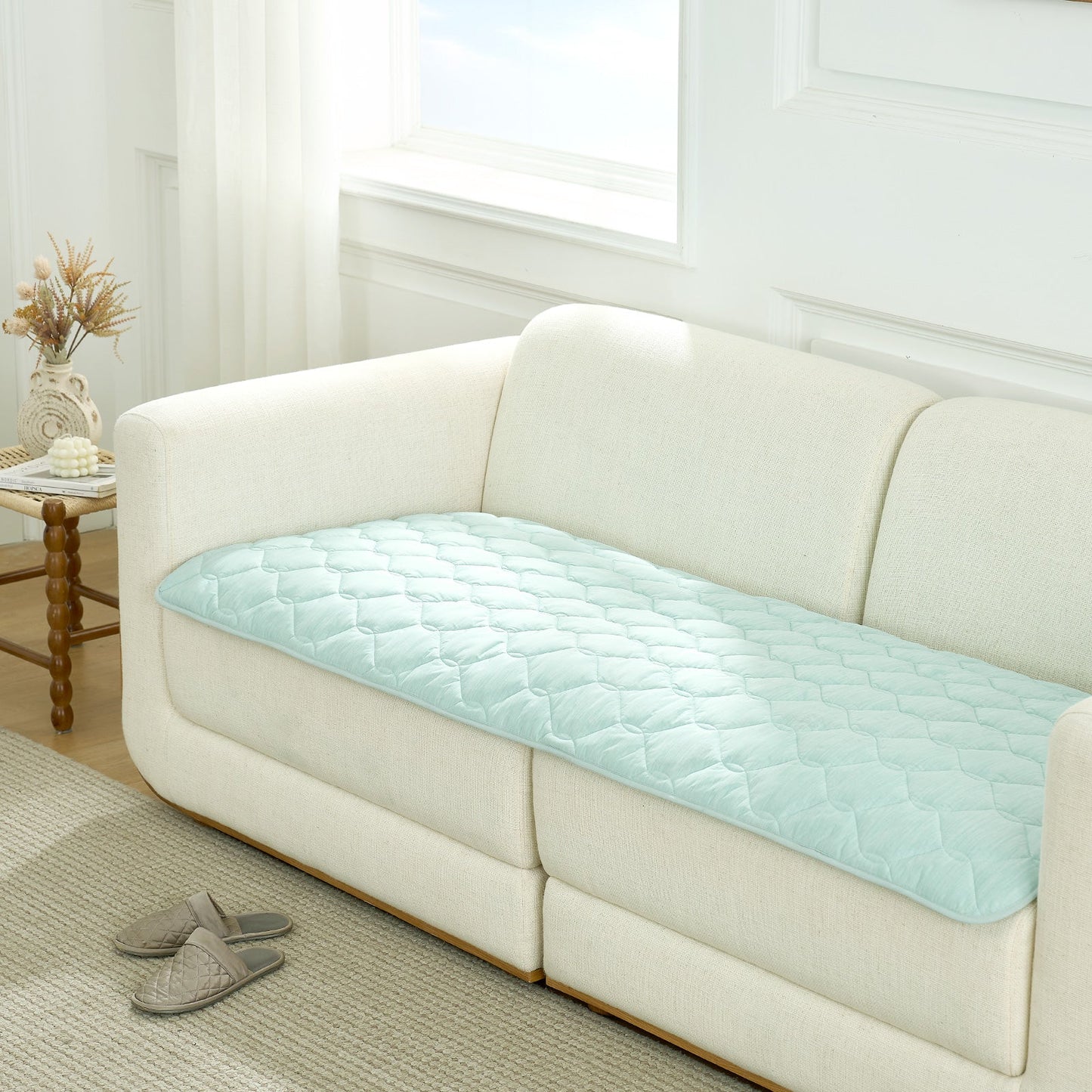 Cozy Kiss green couch cover on a white sofa in a living room setting.#Color_Sage Green