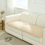 Beige couch cover on a white sofa in a living room setting.