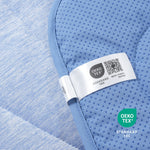 Close-up of a blue textured fabric with an Oeko-Tex label.