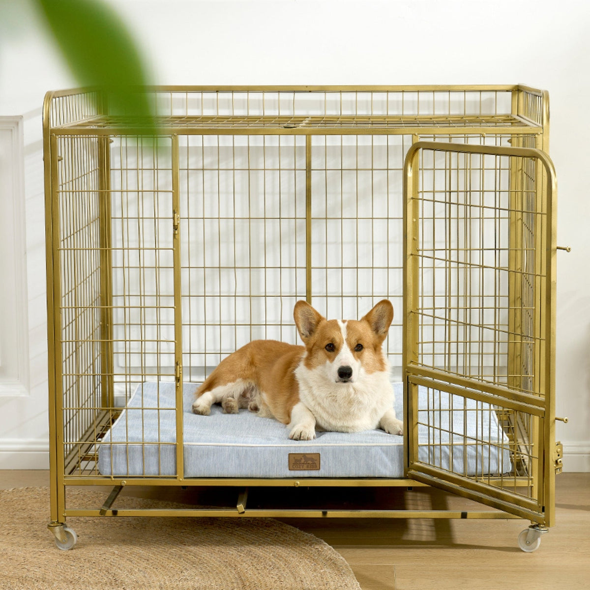 Dog lying on a cooling cushion inside a gold metal dog crate.